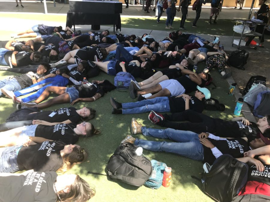 Students lay out on Senior Lawn donning shirts that say I was killed by a drunk driver.